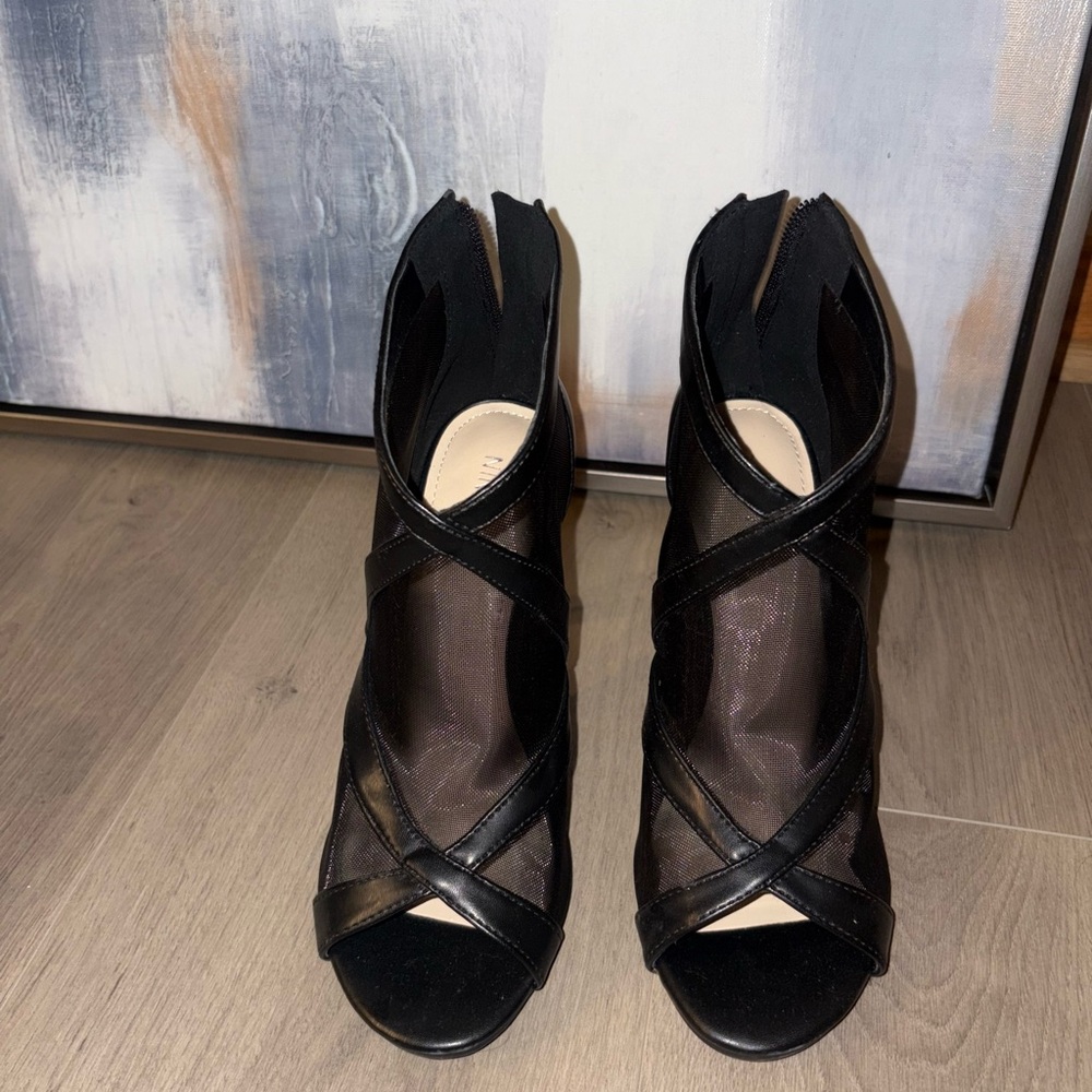 Black mesh ankle heels with leather trim and a stiletto heel.